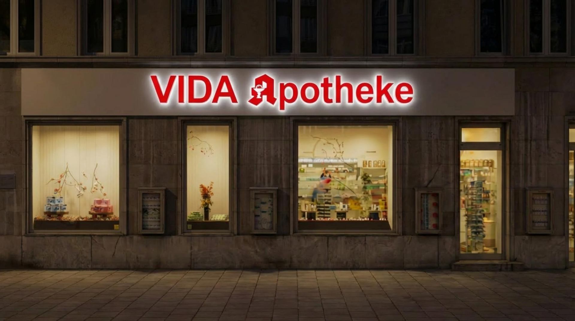 VIDA Apotheke – beleuchtete Fassade bei Nacht